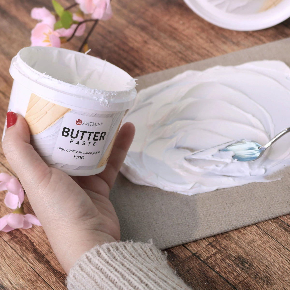 Otvorena posuda i sloj paste ARTMIE Butter Fine nanesen na platno špahtlom