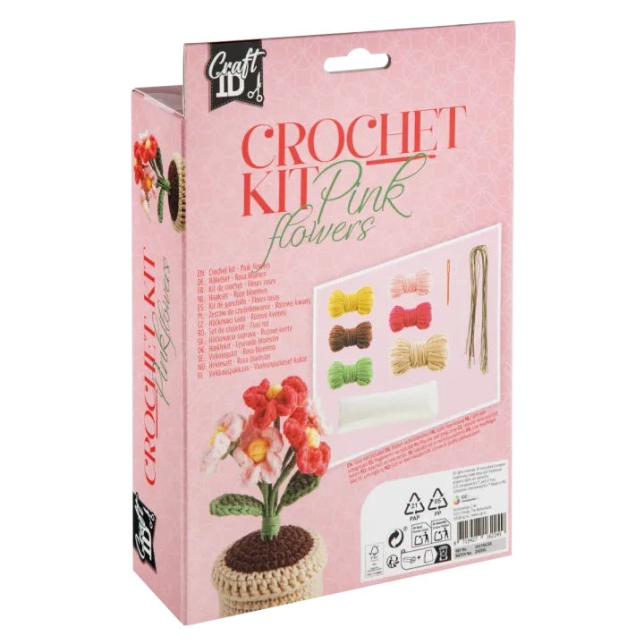 Gotova heklana saksija sa ružičastim cvijećem pored alata iz DIY seta.