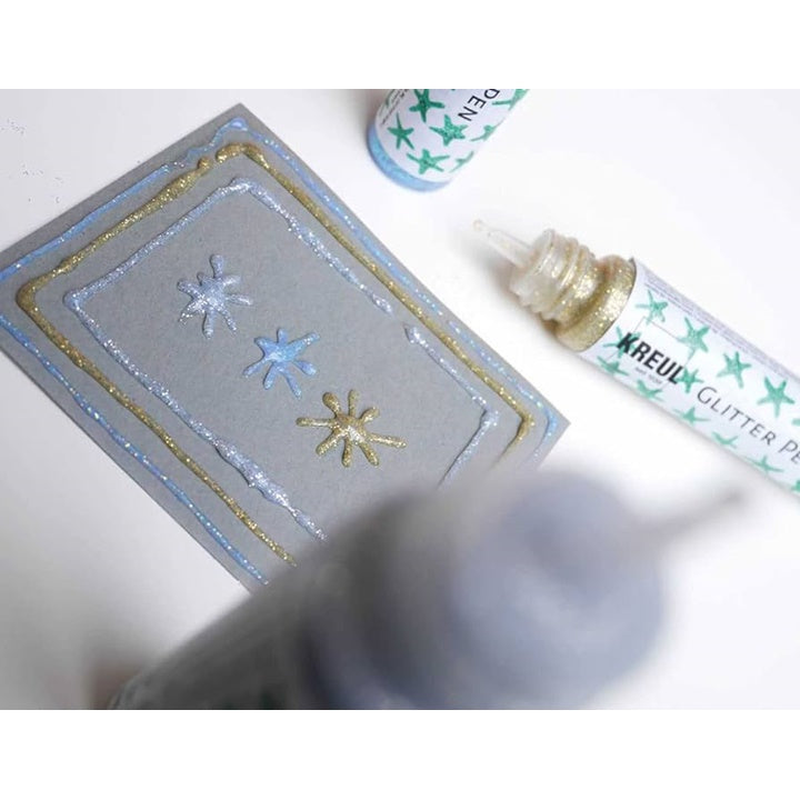 Krupni plan KREUL Glitter Pen olovke u tubi, idealne za precizno nanošenje šljokica na papir, drvo ili staklo.