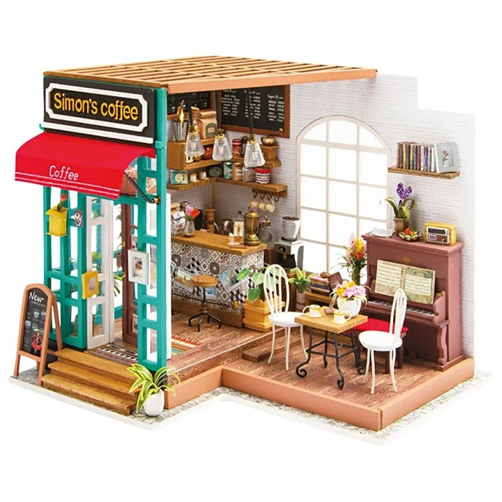Gotov model minijaturne kafeterije iz kreativnog seta, prikazan sa upaljenim dekorativnim osvjetljenjem.