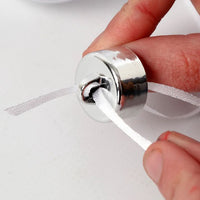 Svečano dekorisane božićne kuglice iz kreativnog seta koje vise na grani jelke.